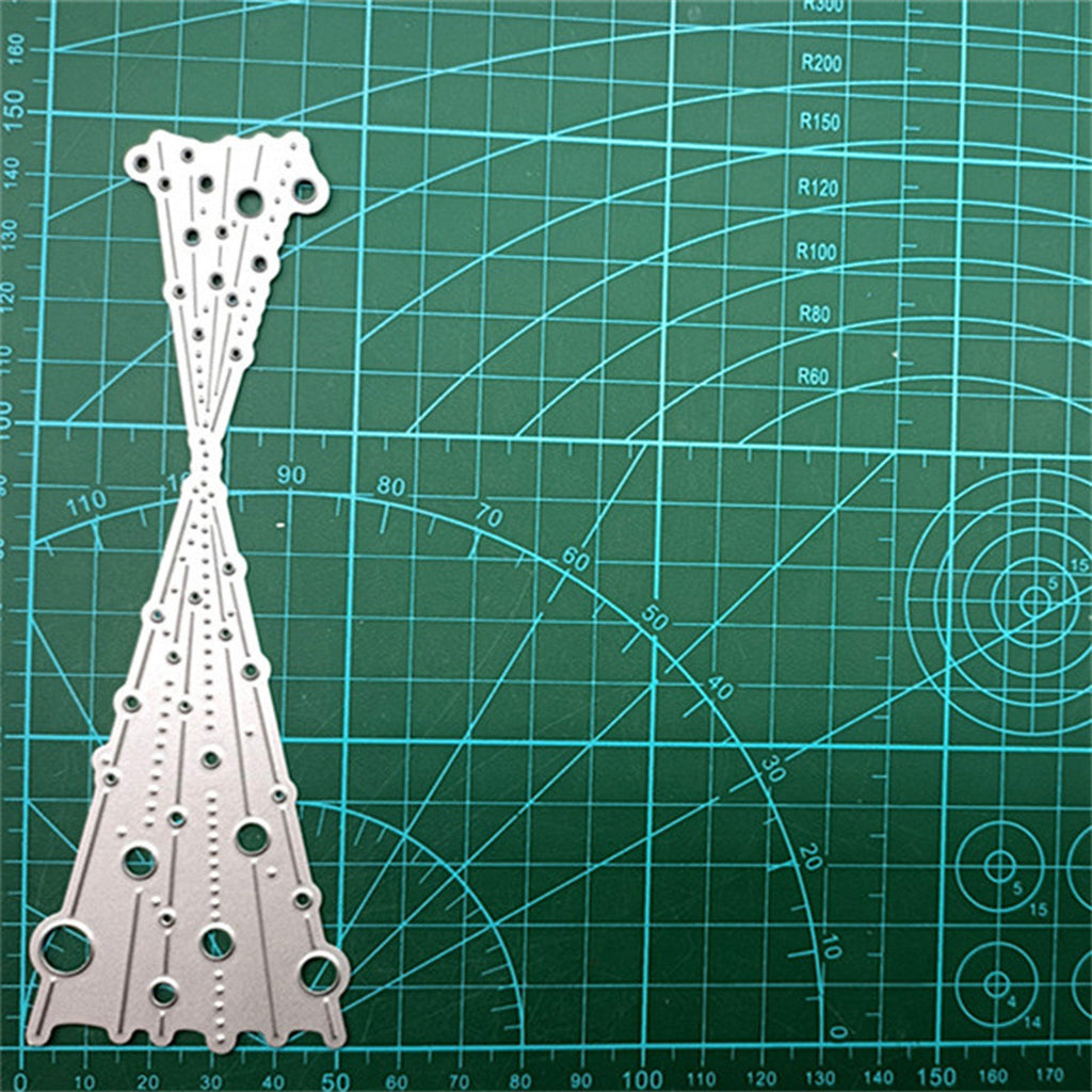 Silver metal cutting die with bubble spray pattern shown on green gridded cutting mat
