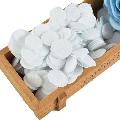 White round felt circles piled in a small wooden crate