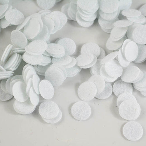 White round felt circles scattered on a white background
